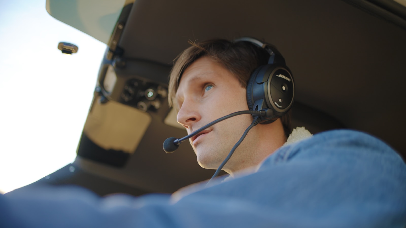 Pilot wearing headset in cockpit, illustrating voice communications